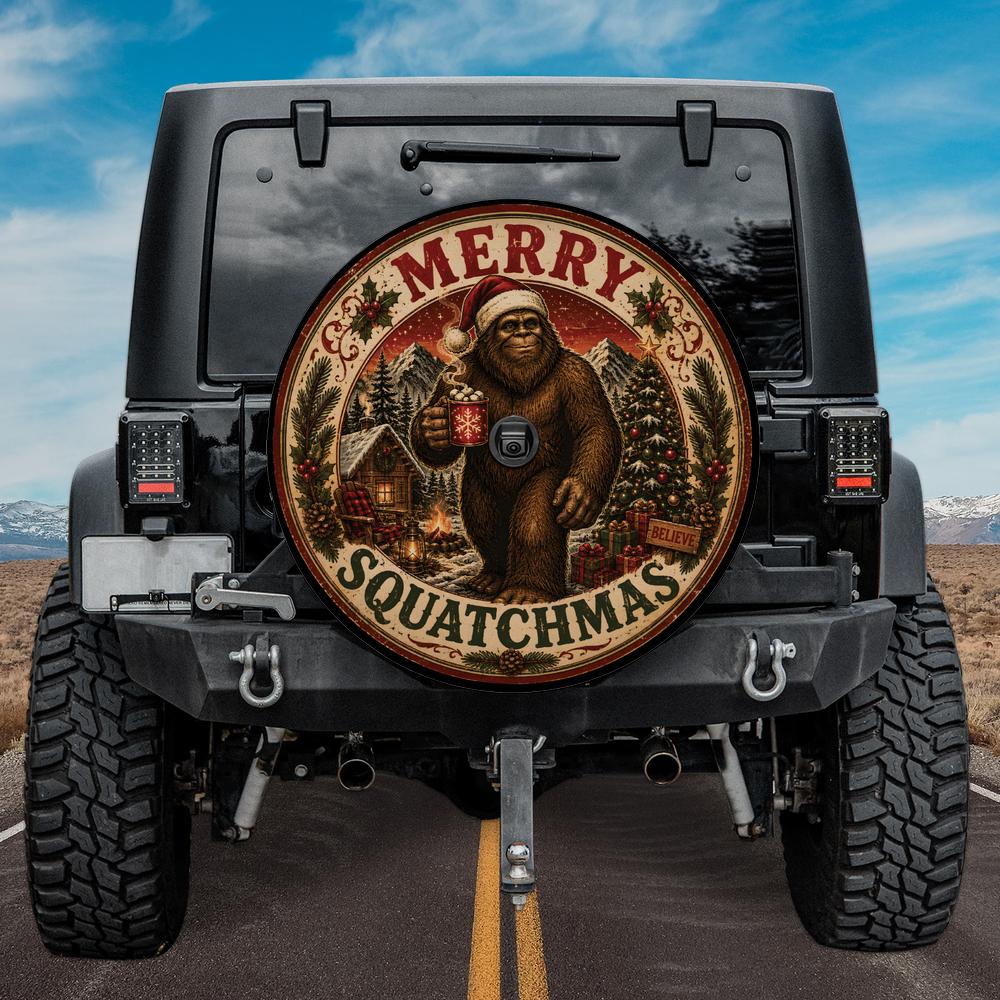 A circular decorative spare tire cover mounted on the back of a black Jeep, featuring a cartoon sasquatch in a Santa hat holding a mug, with the text 'MERRY SQUATCHMAS' and holiday trees and cabins.